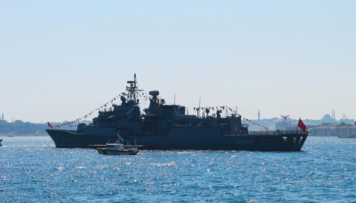 Navy ship on the Bosphorus with Istanbul skyline in background, taken during the day.